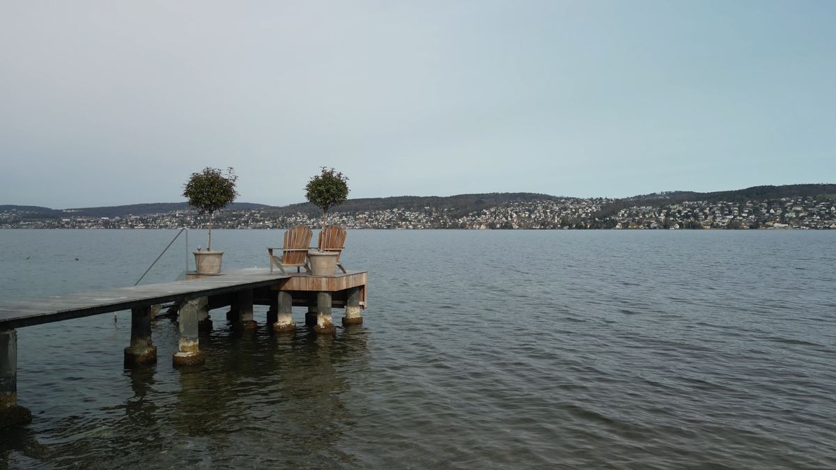 Two chairs on a Lake Zurich pier — one website serving two languages